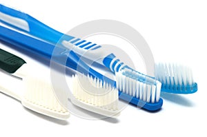 Four white and dark blue toothbrushes against a white backdrop