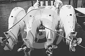 Four white, 425 hp outboard motors, tilted out of the water