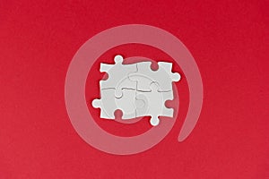 Four white missing peace of puzzle jigsaw on red background. Business concept. Finish what you start. Team work and partnership.