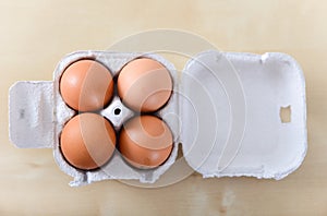 Four whole eggs in egg container