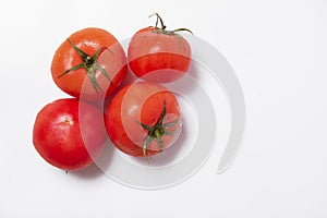 Four whole red tomatoes on left on white background
