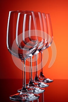 Four wine glasses in row perspective on red-orange background