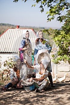 Four women are busy working in the yard. Retro style, countryside, farm