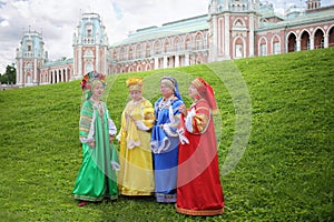 Four women in colorful Russian folk costumes sing photo