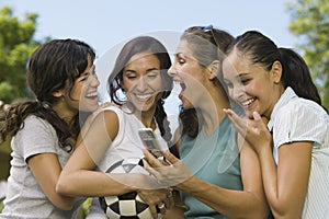 Four Women Laughing At Mobile Phone Display