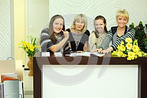 Four women sit in reception area with magazines