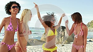 Four women wearing sunglasses partying in their bikinis