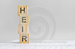 Four wood cubes with the word Heir on the background of white financial tatements, strong business concept