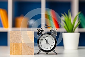 Four wooden cubes with copy space and alarm clock