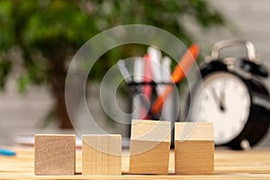 Four wooden cubes with copy space and alarm clock