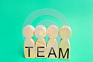 four wooden people with the inscription `team`. group work. teamwork. achievement of goals, corporate spirit. cohesion in the team photo