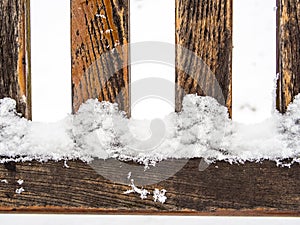 Four wooden rungs or spokes covered with snow