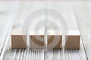 Four wooden toy cubes on grey wooden background