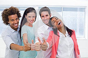 Four workers giving thumbs up and smiling to camera