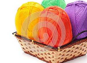 Four yarn skeins in yellow, orange, green, purple colors