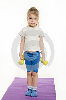 Four-year girl is preparing to raise two dumbbells