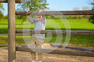 Four year old boy climbing on wooden beams