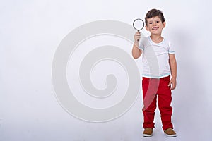 Four years boy looking through a magnifying glass, preschool kids, education. Isolated on white background, modern learning kids.