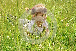 Four years old girl lies in the grass