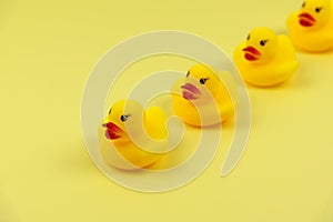 Four yellow rubber duck on yellow background