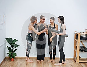 Four Yoginis communicate before classes in class, discussing something