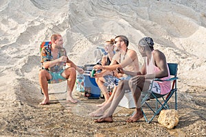 four young adults having fun on the beach