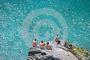 Four young boys sitting rocks watching the day go by