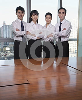 Four Young business people standing by conference table