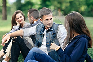 Four young friends looking at each other and communicate outdoor