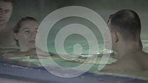 Four young friends are relaxing in the pool