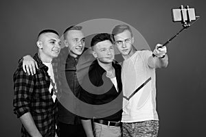 Four young handsome men together against gray background