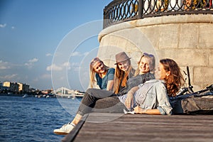 Four young happy girlfriends student teenagers rest together on photo