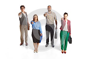 Four young people, businessmen, office workers standing together and looking at camera isolated over white background.
