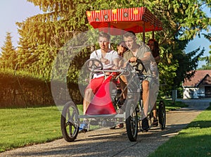 Four young people in a four-wheeled bicycle