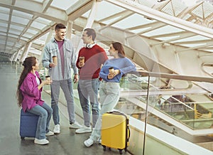 Four Young People Traveling Drinking Coffee In Modern Airport Indoors