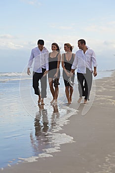 Four Young People, Two Couples, Walking On A Beach