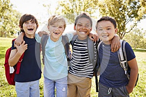 Four young smiling schoolboys hanging out on a school trip