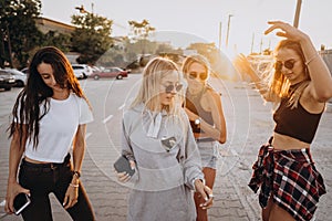 Four young women dance in a car park