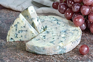 Fourme Ambert semi-hard French blue cheese made from raw cow milk served as dessert with grapes