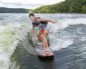 Fourteen year-old Amerasian boy wake surfing on Grand Lake in Oklahoma.