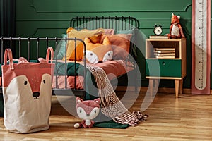 Fox theme in cute bedroom interior with green wall and orange bedding