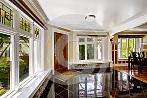 Foyer with black shiny tile floor and stone trim under the windows