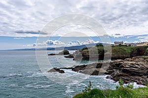 Coastline in Galicia near Foz with green meadows and homes on the seashore photo