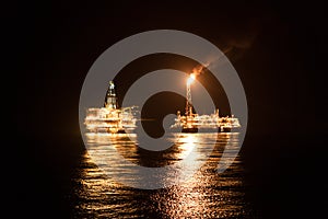 FPSO tanker vessel near Oil Rig at night. Offshore oil and gas industry