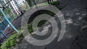 FPV of biker riding bike in park shadows on sunny day