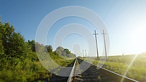 FPV drone flight fast and close to railroad tracks in a clear sunny day