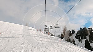 FPV POV of cable chair ski lift ascend for alpine skiing in Dolomites, Italy
