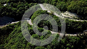 FPV semi truck driving along mountain road going through forest landscape in countryside. F