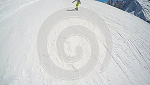 FPV Skier slopes down hill following shadow. Good weather for skiing. Action camera is on helmet. Skiers and