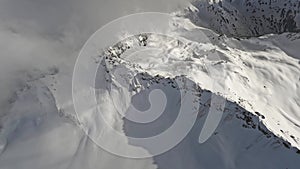 FPV sports drone shot winter mountain ridge fog picturesque snowy summit valley frozen landscape